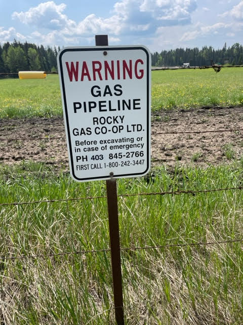 A buried-line warning sign on the right-of-way.